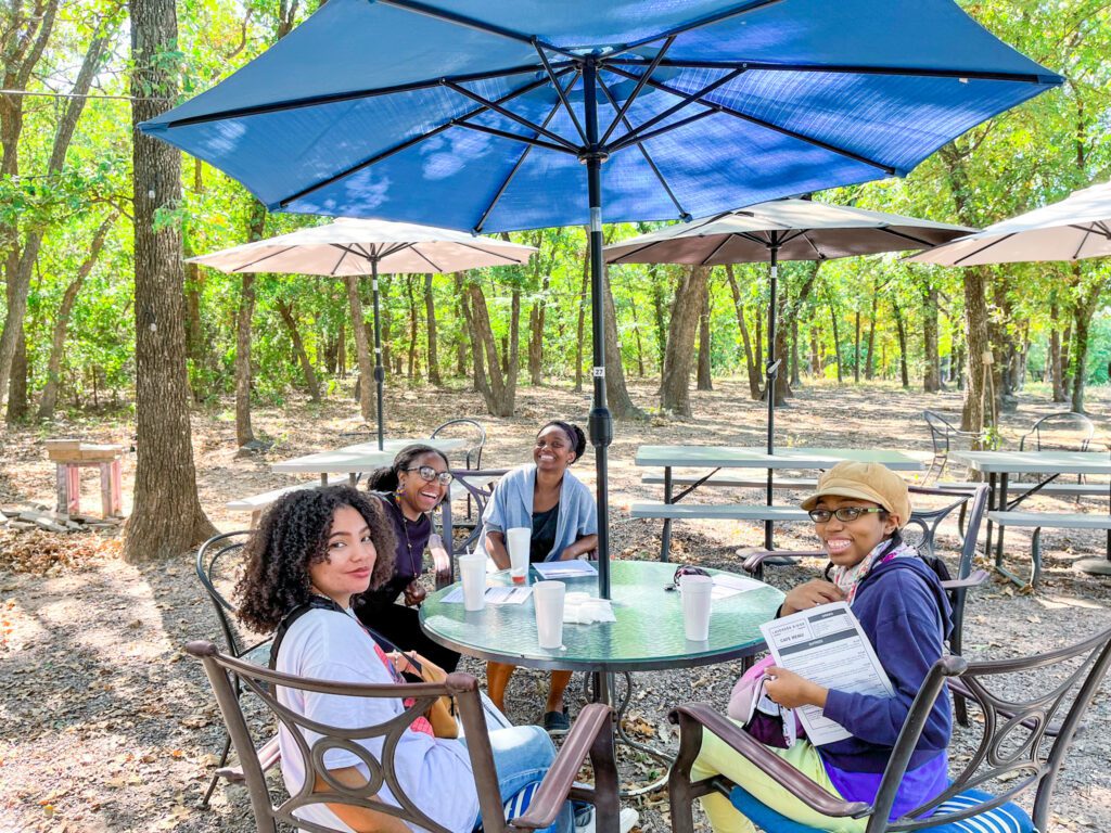 Visitors seated around an outdoor table under umbrellas at Lavender Ridge Farms.