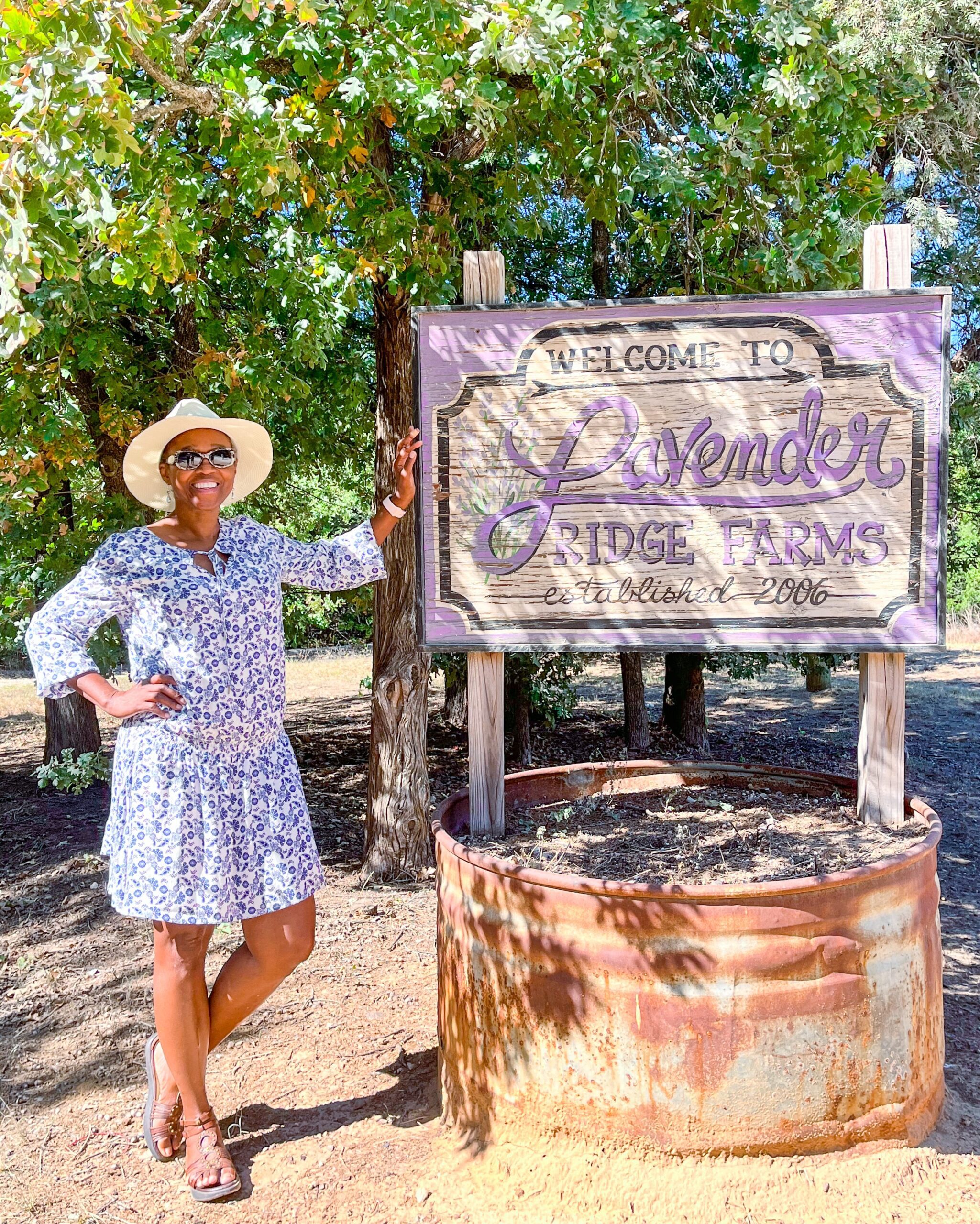 is dallas worth visiting with kids? The lady standing in front of this Lavendar Farms sign says it is and she loves the place. Lavendar Farms is a short road trip from Dallas