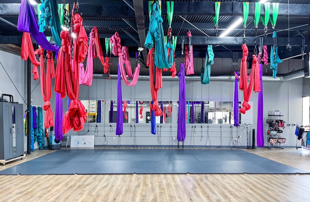 Colorful aerial silks hang from the ceiling in a Dallas studio for indoor activities
