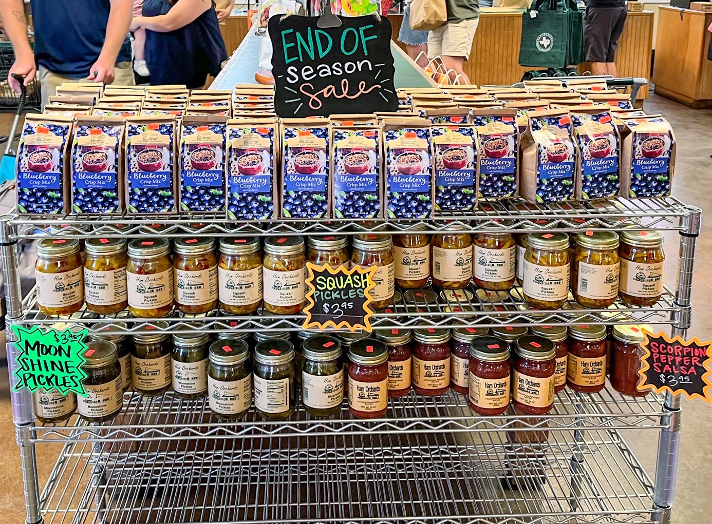 Clearance items on end-of-season sale at Ham Orchards, one of the Dallas Farms near Dallas, Texas, including blueberry muffin mix, squash pickles, moonshine pickles, and scorpion pepper salsa.