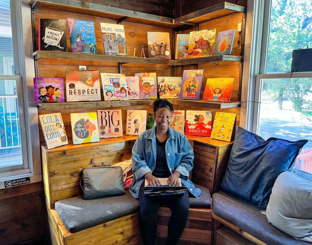 Woman sitting with laptop in cozy bookstore nook at The Wild Detectives bookstore and cafe.