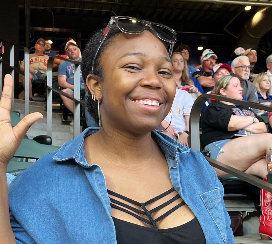 Young lady waving at Dallas Baseball game