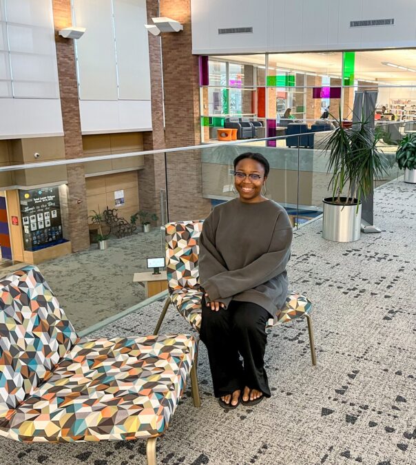 young lady sitting in seating area on second floor at the Lewisville branch library