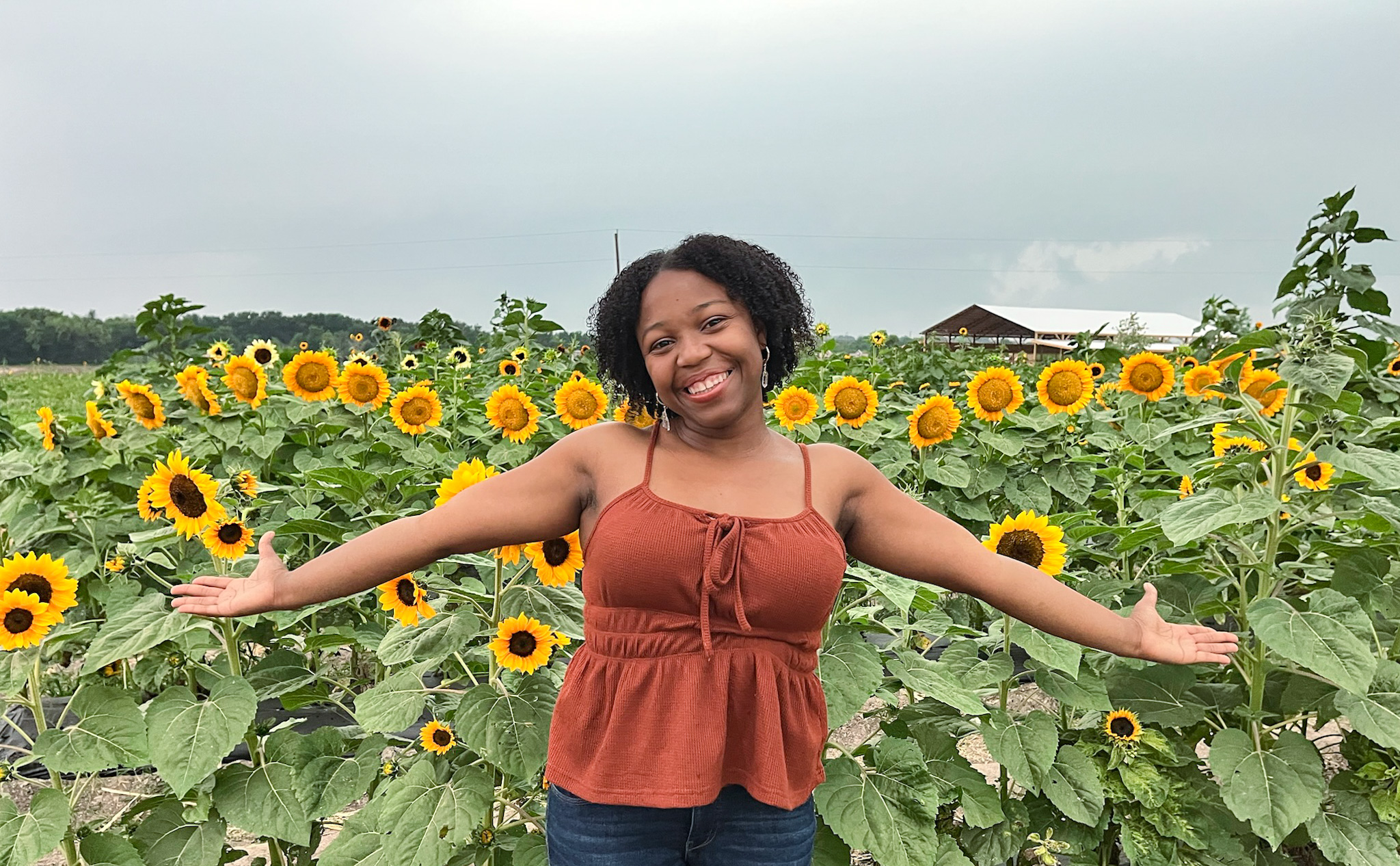 Woman with arms outstretched in one of the sunflower fields near Dallas.