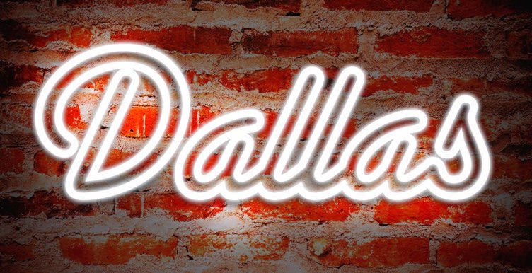 White neon Dallas sign glowing against a red brick wall in Dallas, a popular photo spot and one of the free things to do in Dallas with kids.