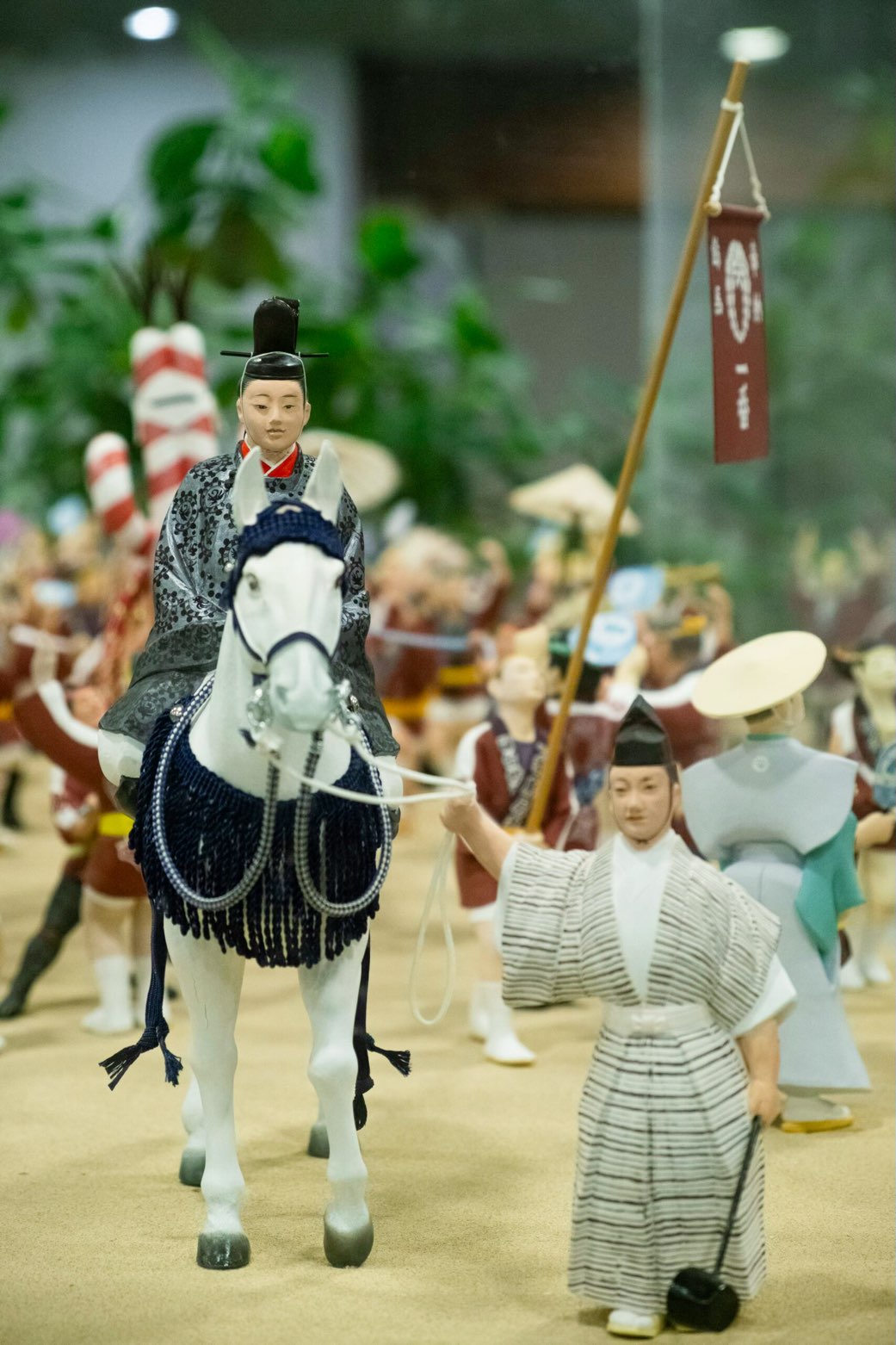 Samurai figurines with a Samurai sitting on a horse being led by a servant in a detailed landscape scene at the Samurai Collection, one of the free things to do in Dallas with kids.