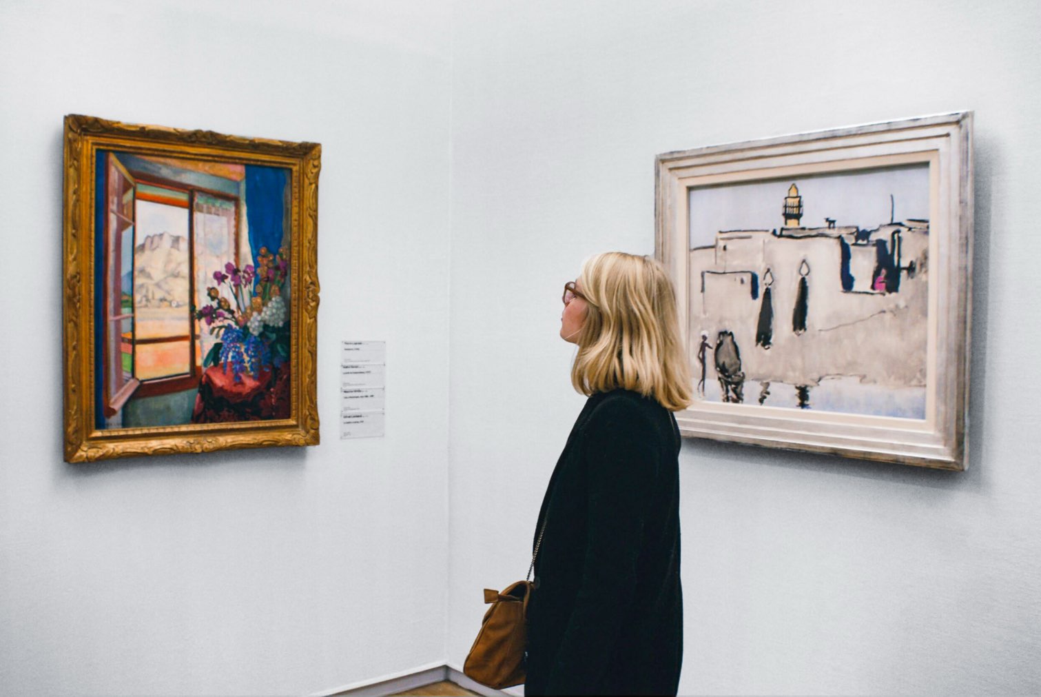 Young woman gazing at a painting of a vase of flowers in front of an open window with mountains at the Dallas Museum of Art, one of the free things to do in Dallas with kids.