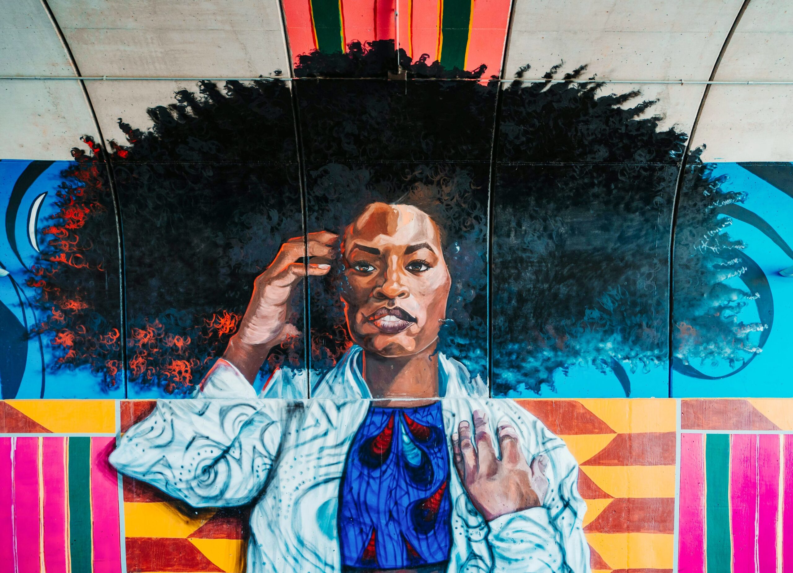 Painted portrait of a young Black woman in block style with a large afro at the African American Museum of Dallas, one of the free things to do in Dallas with kids.