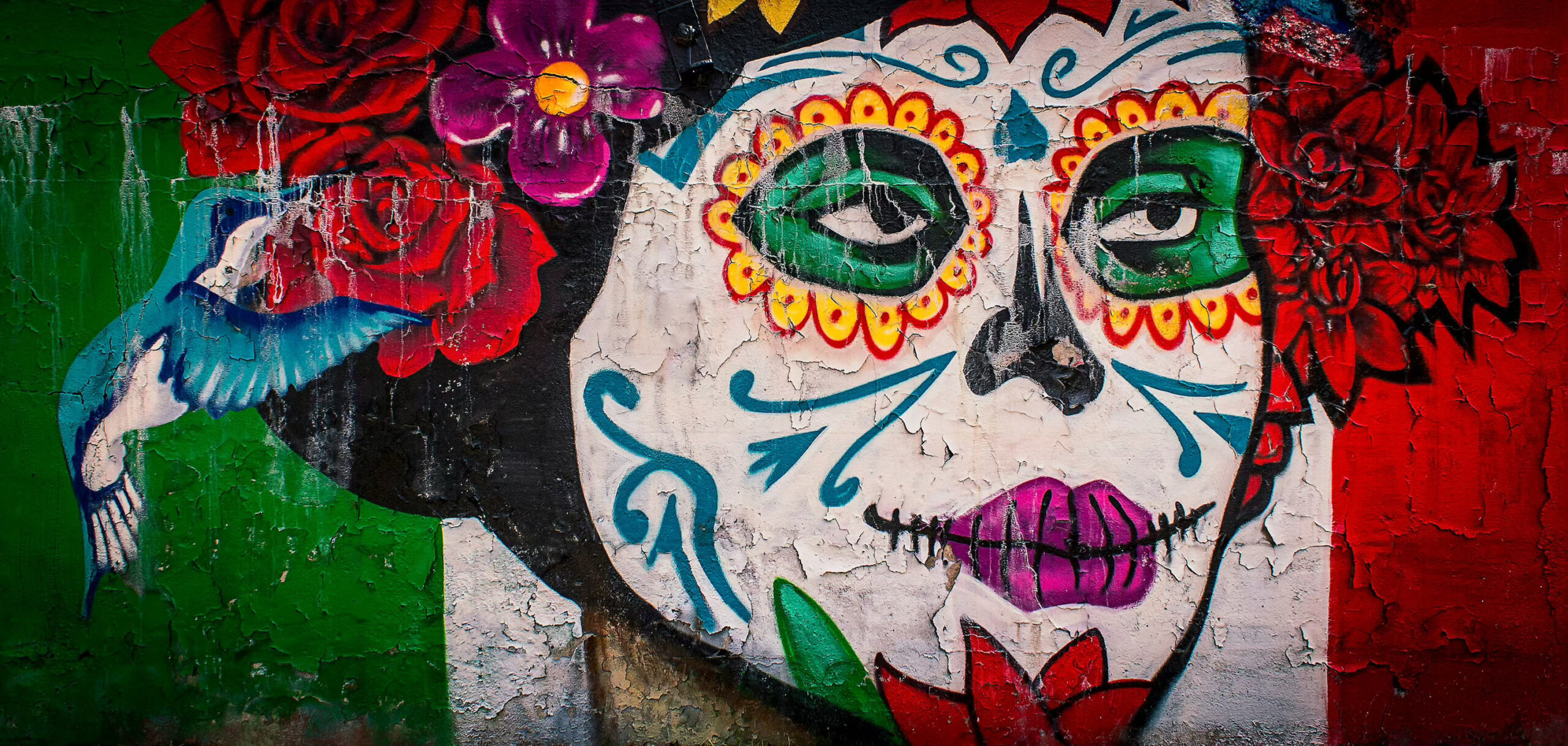 Painting of colorful masked face on wall at Latino Cultural - one of the many free museums in Dallas Center