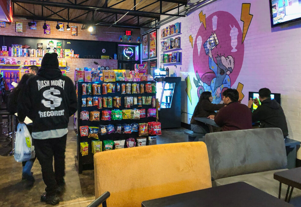 Interior of Spelled Milk with colorful wall art, sweets, and seating at a popular late-night hangout in Dallas.