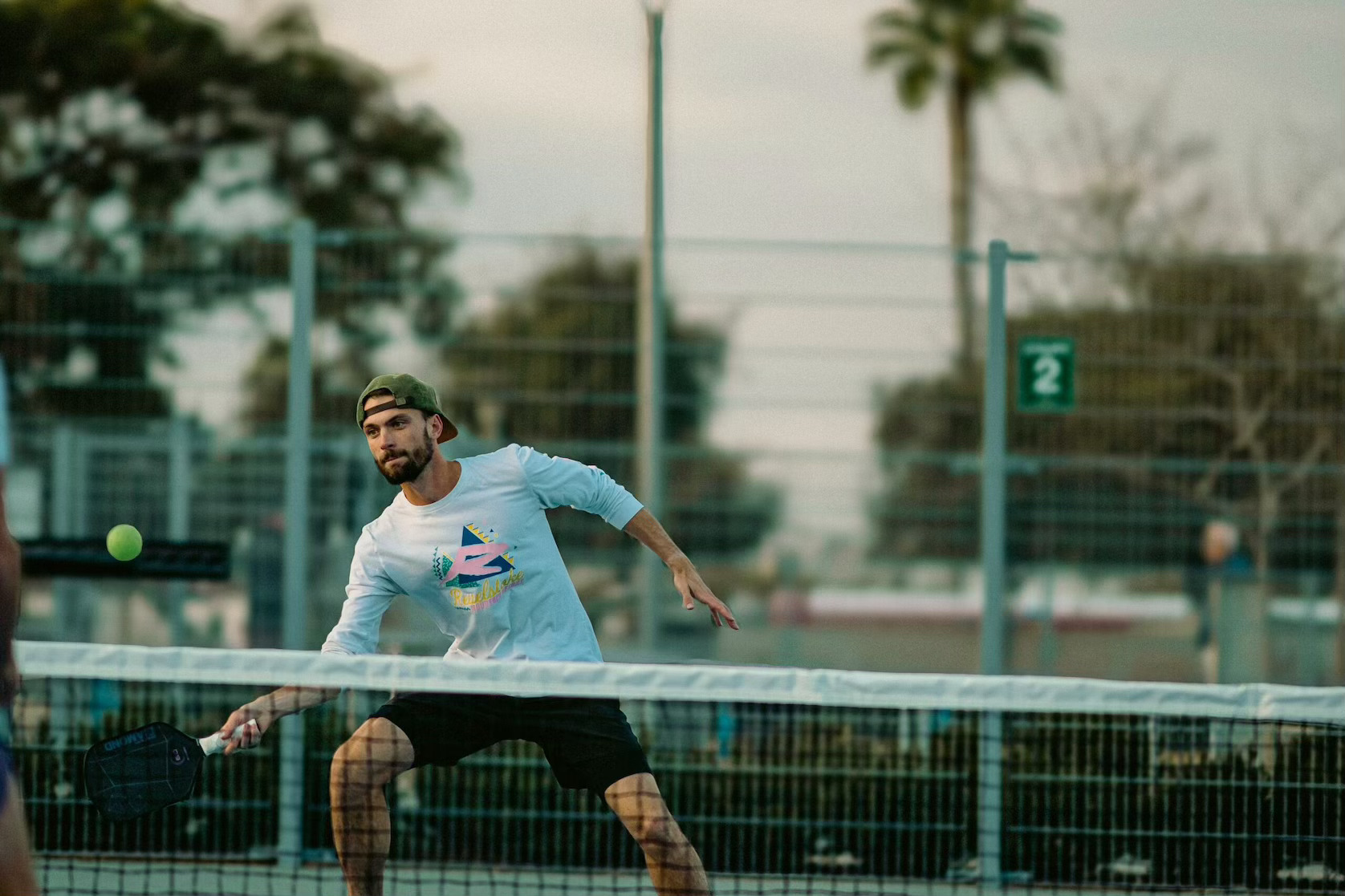 Man hitting a pickleball shot on a court, highlighting Dallas sports leagues and affordable adult sports options