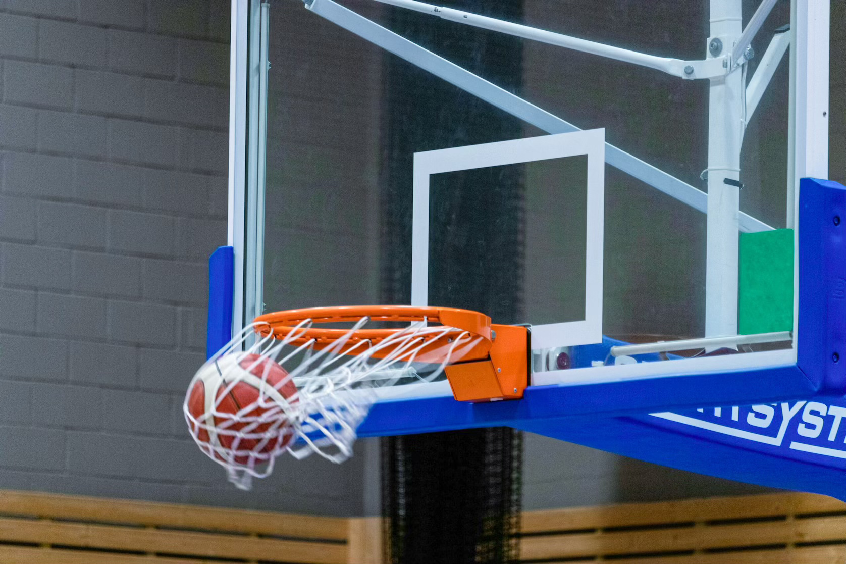 Basketball swishing through hoop during a game, representing Dallas sports leagues and adult recreational basketball opportunities