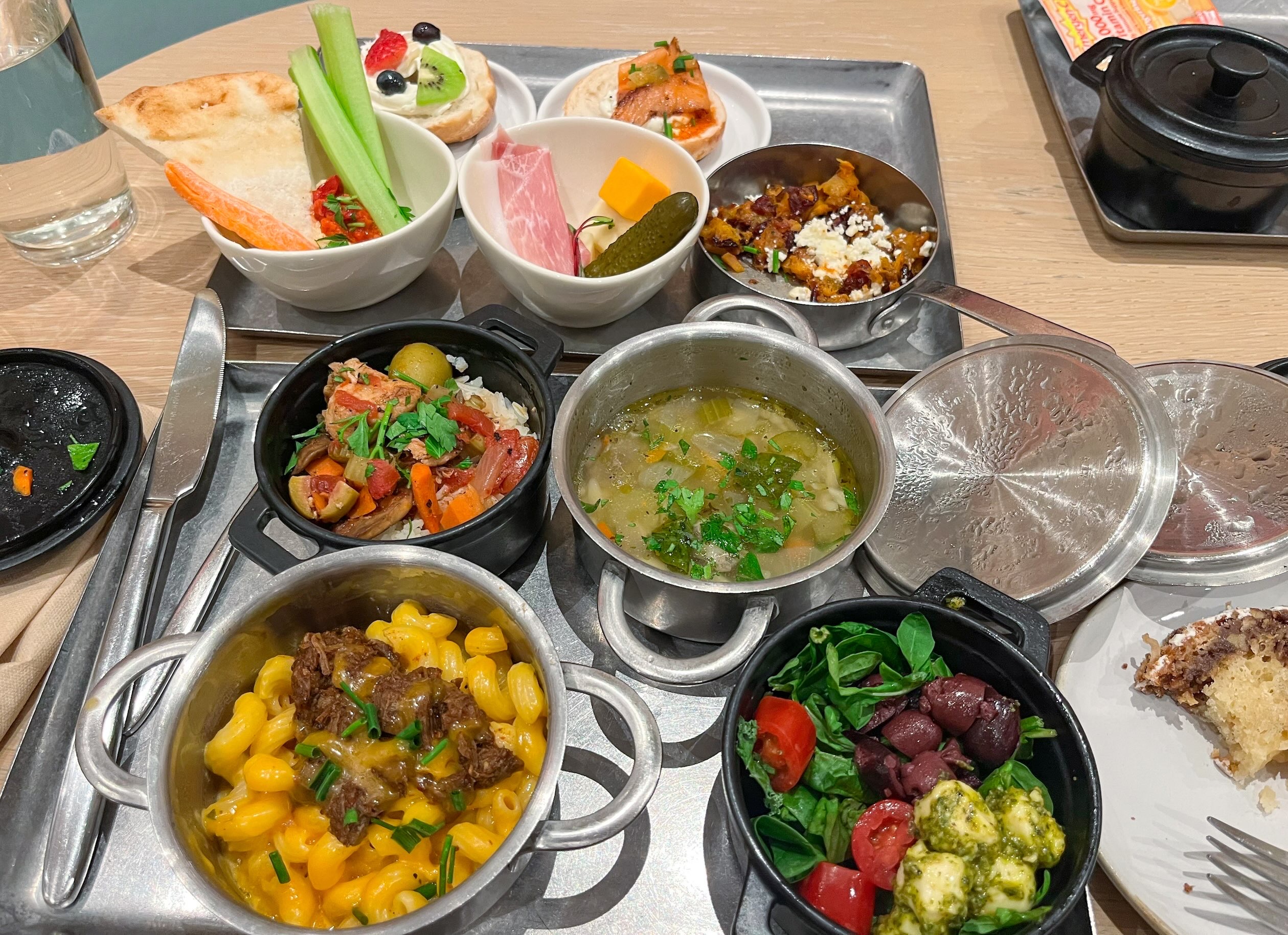 Two serving trays filled with appetizing food dishes inside the Capital One Lounge at DFW Airport, part of the Dallas airport lounges.