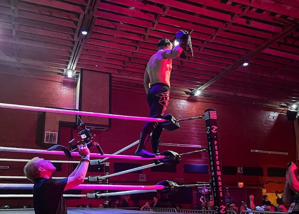 DFW wrestling at Smash Mouth Wrestling in Haltom City with a wrestler standing on the ropes and arms spread wide to the cheering crowd