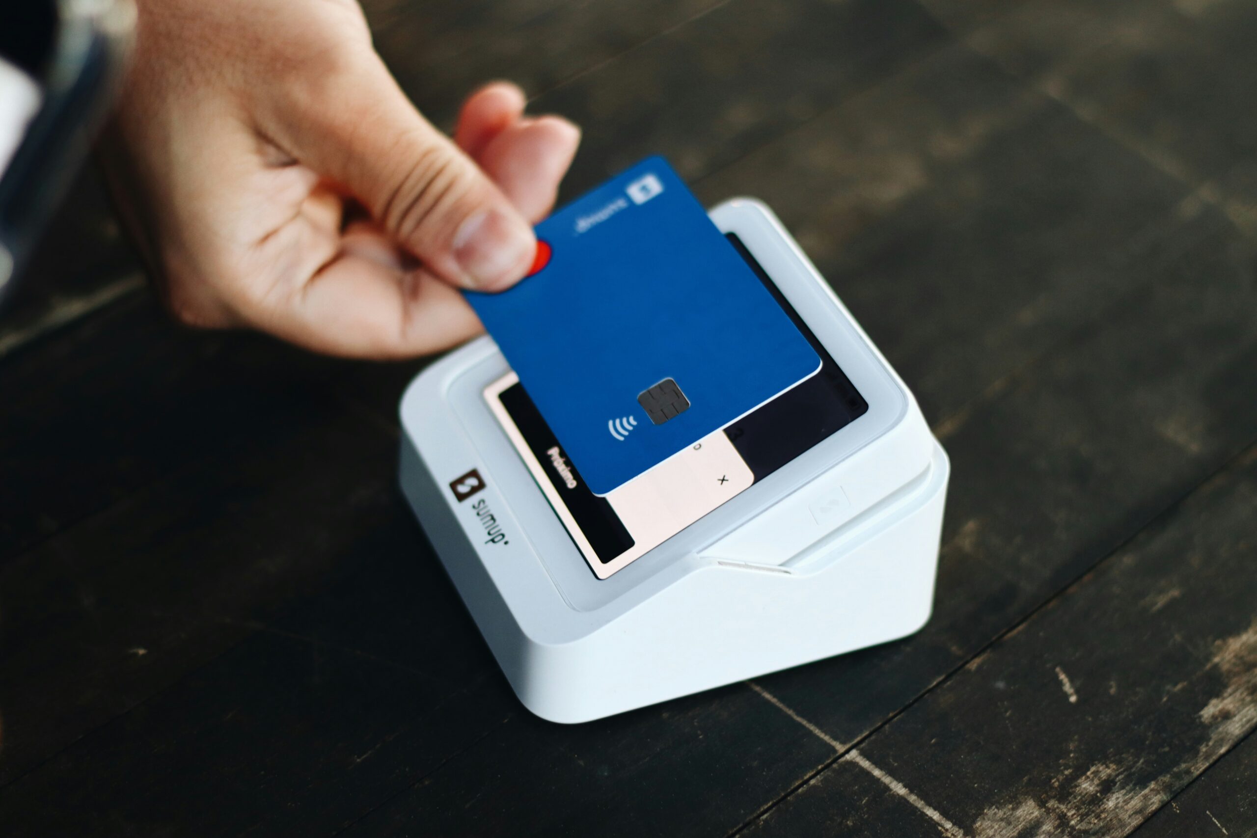 Traveler swiping a credit card that provides airport lounge access benefits at DFW, home to popular Dallas airport lounges.