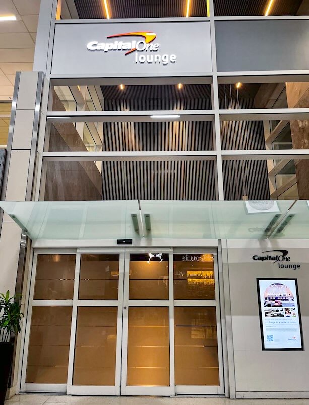 Entrance to the Capital One Lounge in Terminal D at DFW Airport, providing travelers access to premium amenities, comfortable seating, and complimentary Dallas airport food and beverages.