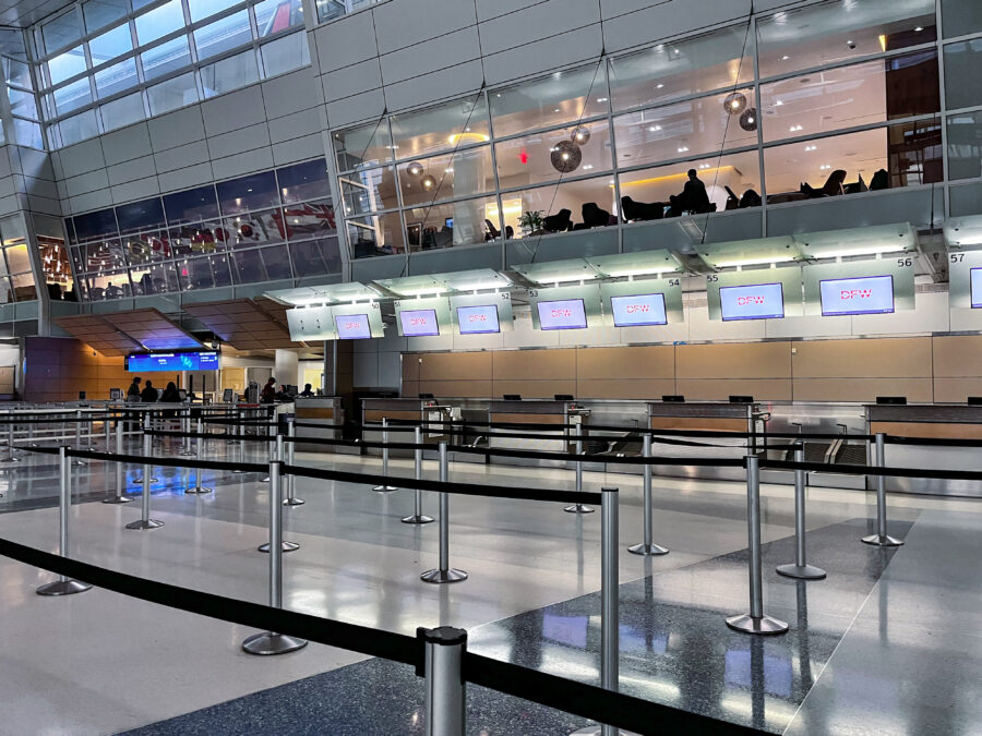 Ticketing counters and queue line markers in Terminal D at DFW Airport, where travelers check in before exploring Dallas airport food options and departing flights.