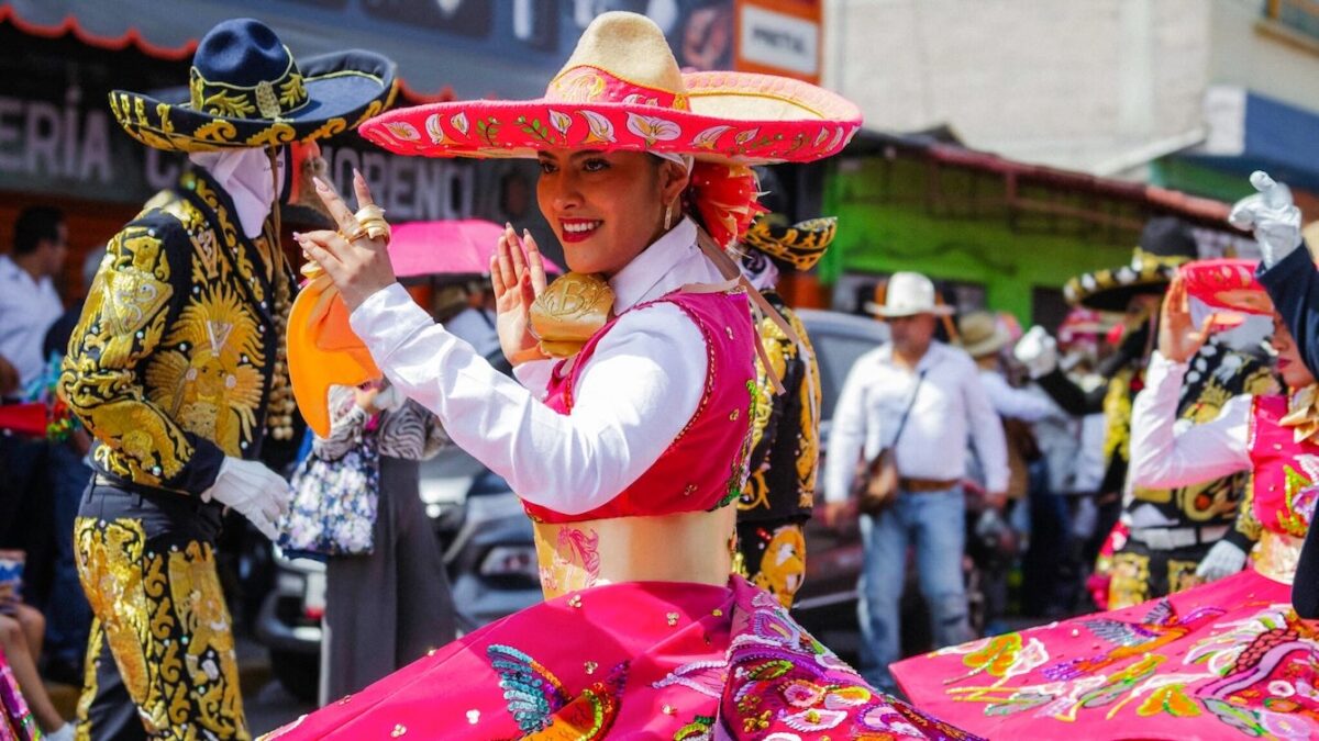 Dancers in vibrant sequined costumes perform at a Dallas fall festival cultural celebration.