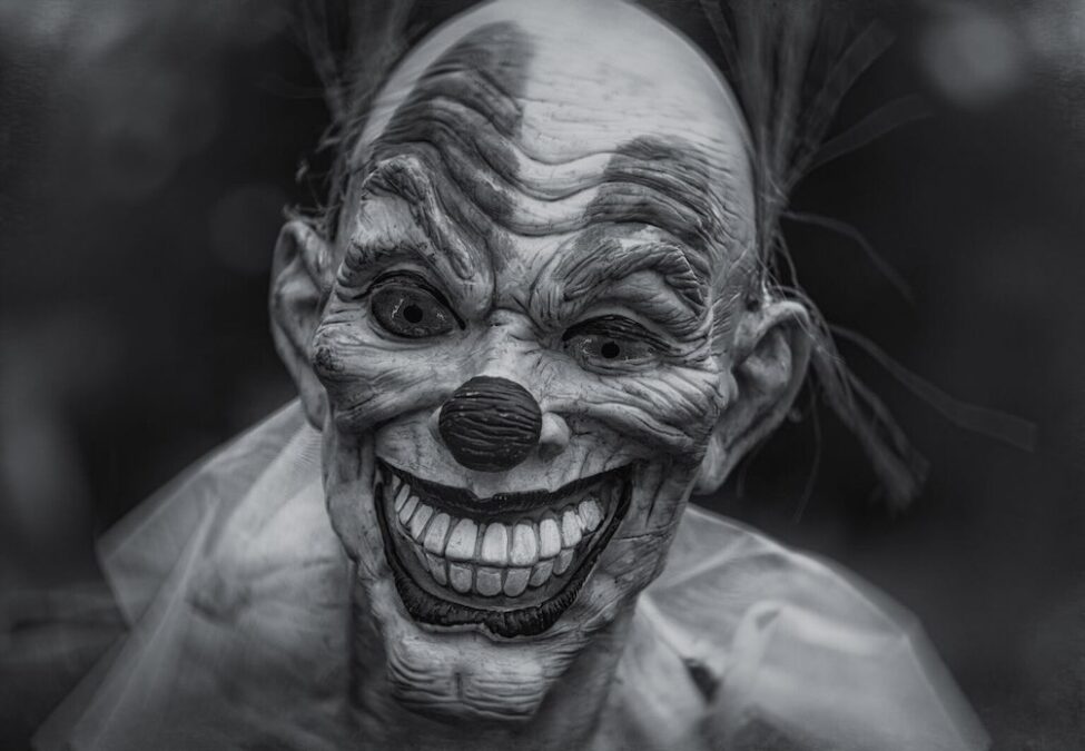 Creepy smiling humanoid character with large ears and teeth inside a haunted house at a Fort Worth Halloween attraction.