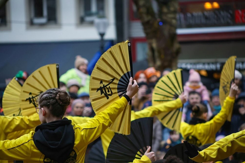 Young dancers perform with raised fans at the Dallas Mid-Autumn Moon Festival celebrating Asian culture.