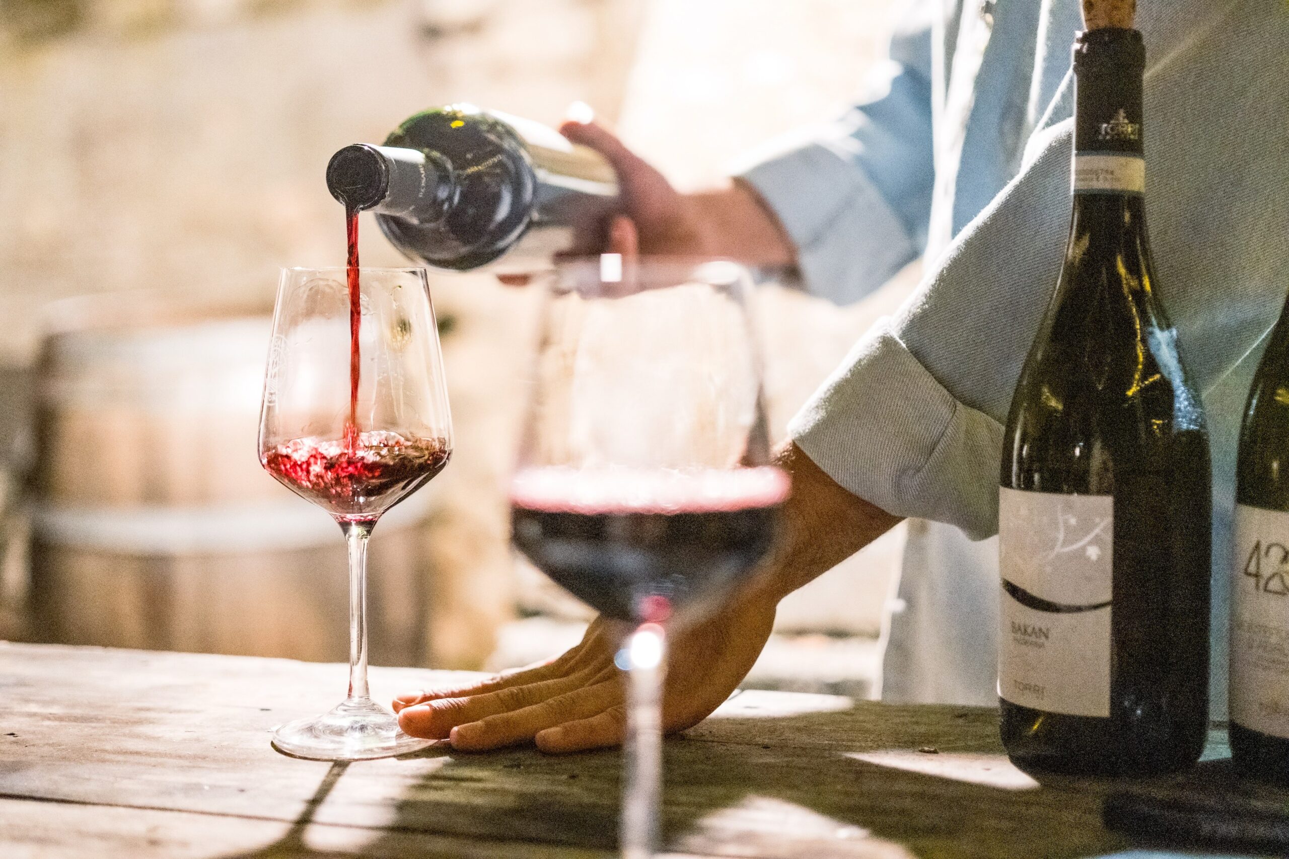 A server pours red wine into a glass at a wine tasting during Christmas in Grapevine.