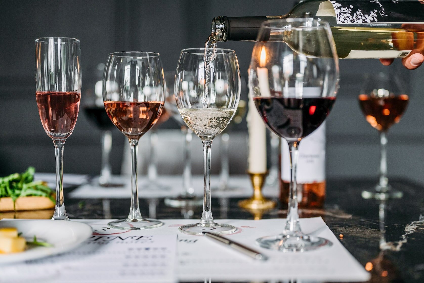 Red, rosé, and white wines are served into glasses on a tasting bar during Christmas in Grapevine.