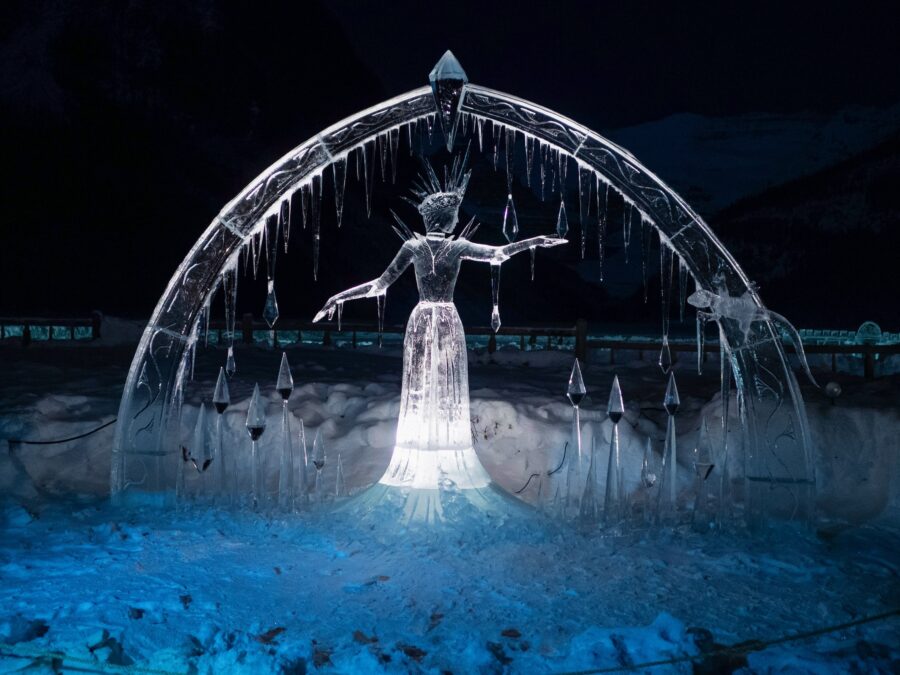 Back view of an ice sculpture of a woman with outstretched arms beneath an icy arch during Christmas in Grapevine.
