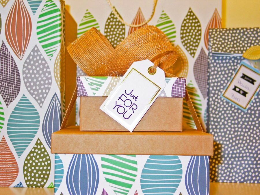 Stacked Christmas gift boxes wrapped in plain paper with a decorative top box and a “Just For You” gift tag during Christmas in Grapevine.