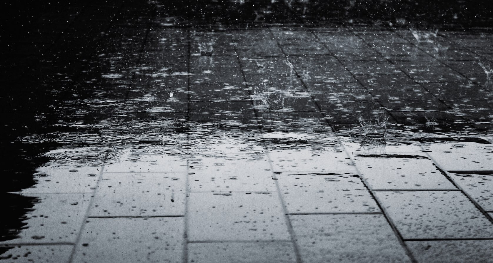 Raindrops bouncing off wet cement during Dallas in Winter