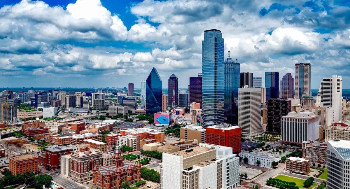 Aerial view of downtown Dallas featuring mirrored high-rise buildings and colorful brick structures during winter in Dallas.