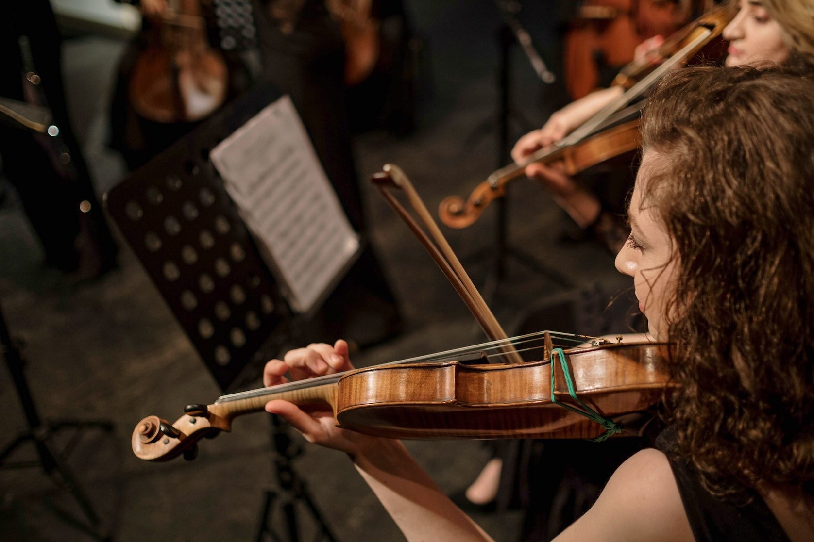 Young violinist holding her violin and bow before a holiday concert performance during winter in Dallas.
