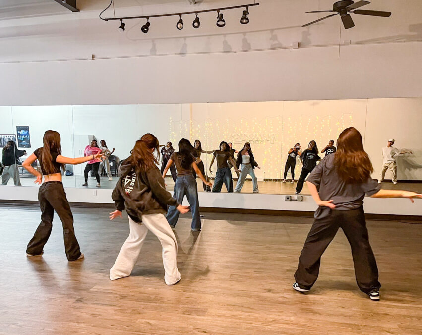 K-pop dance students follow an instructor during indoor dance class in Dallas