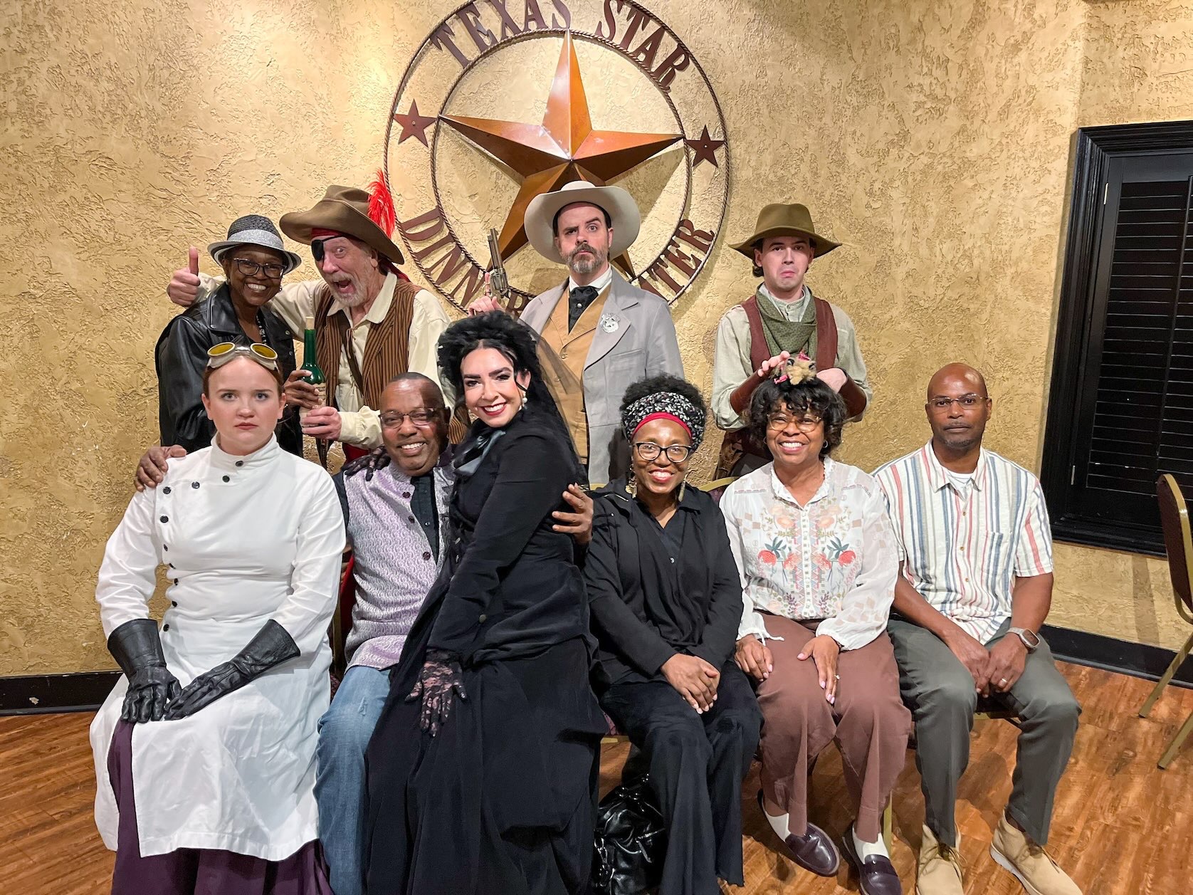 Family and friends pose with costumed actors during an interactive 1800s Wild West murder mystery dinner at Texas Star Dinner Theater, a unique-things-to-do-in-dfw experience.