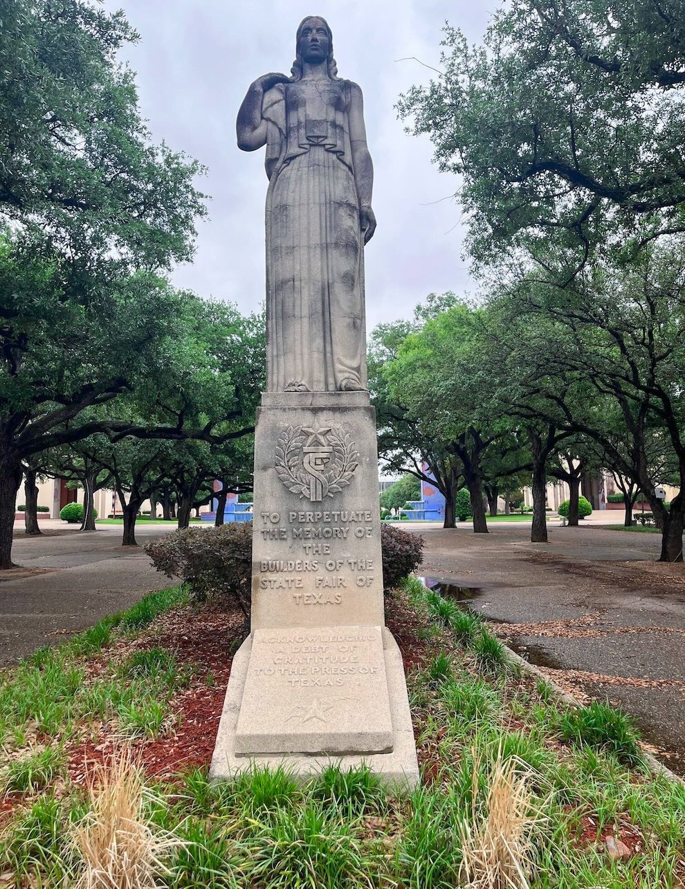 Commemorative statue of a solemn woman inside Dallas Fair Park honoring the builders of the State Fair of Texas, a unique-things-to-do-in-dfw attraction.