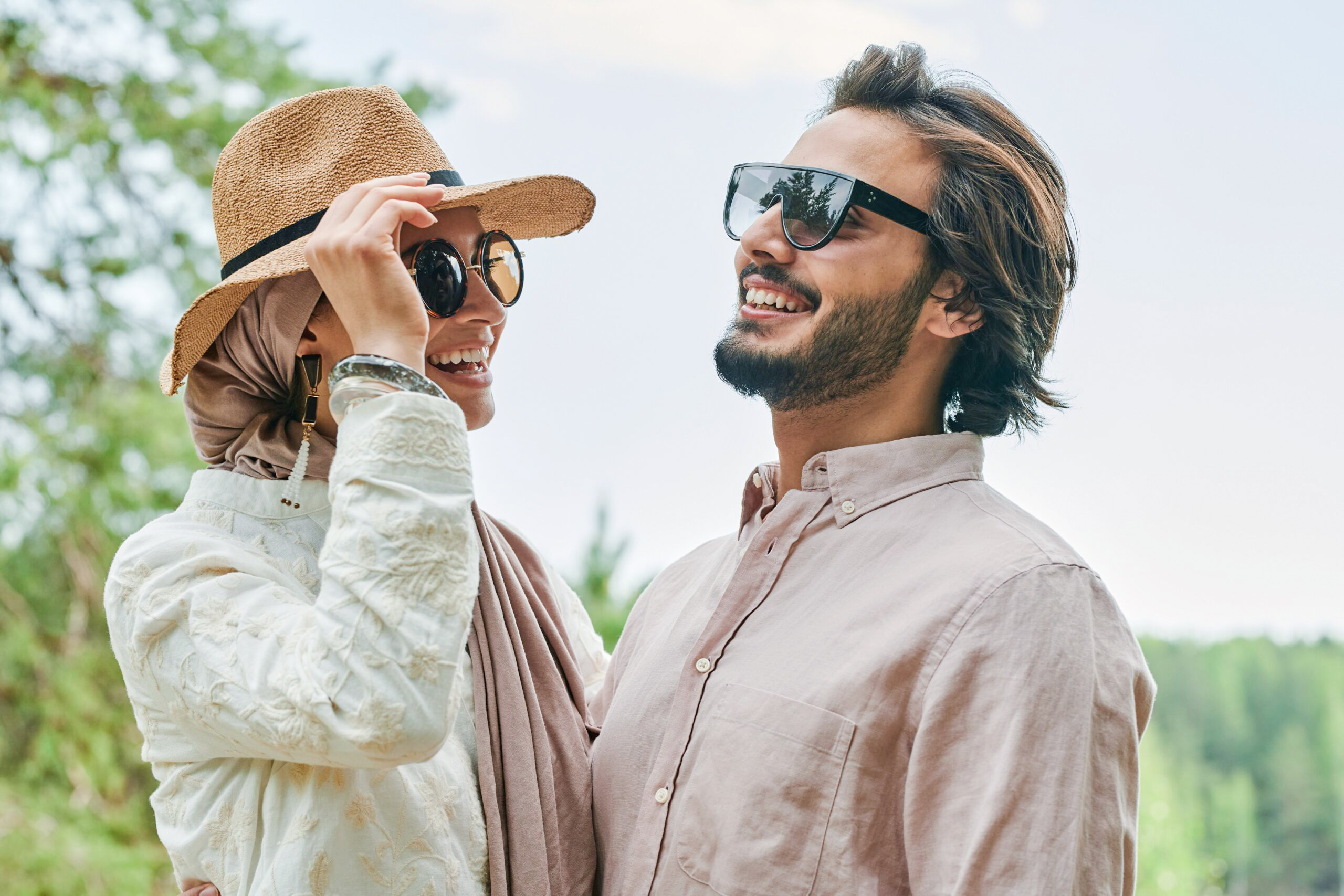 A smiling couple faces each other outdoors, enjoying a lighthearted moment while exploring free things to do in Dallas for couples.