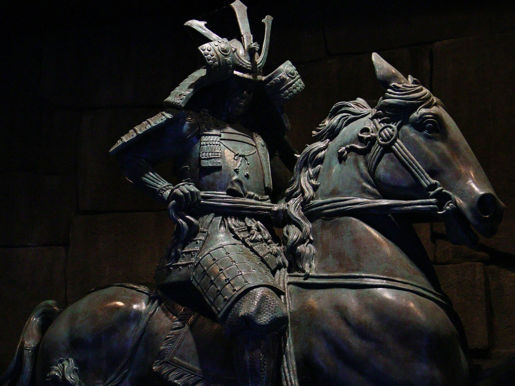 Bronze samurai on horseback with greenish-black patina, reminiscent of Dallas's samurai art collection and a cultural date idea for couples.